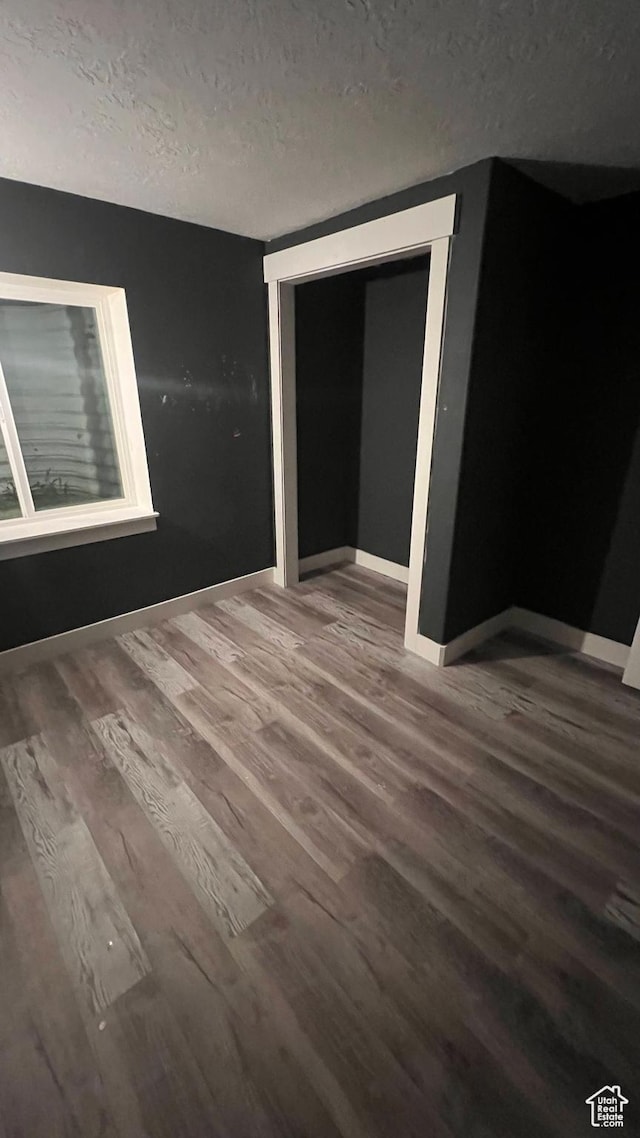 539 S Chan Dr, Grantsville, UT 84029 - unfurnished bedroom with wood finished floors, a textured ceiling, and a closet