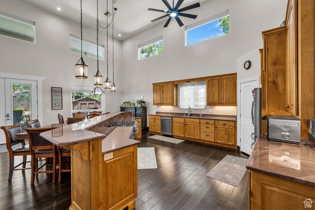 2119 Blair Cir, Santa Clara, UT 84765 - kitchen featuring a towering ceiling, dishwasher, ceiling fan, brown cabinets, and dark wood-style flooring