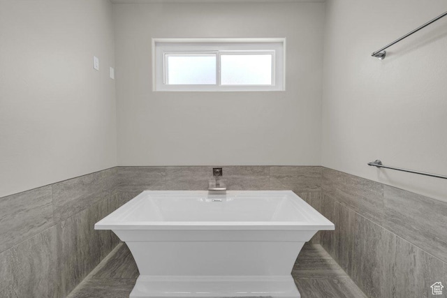 2119 Blair Cir, Santa Clara, UT 84765 - bathroom with tile walls, a soaking tub, and a wainscoted wall