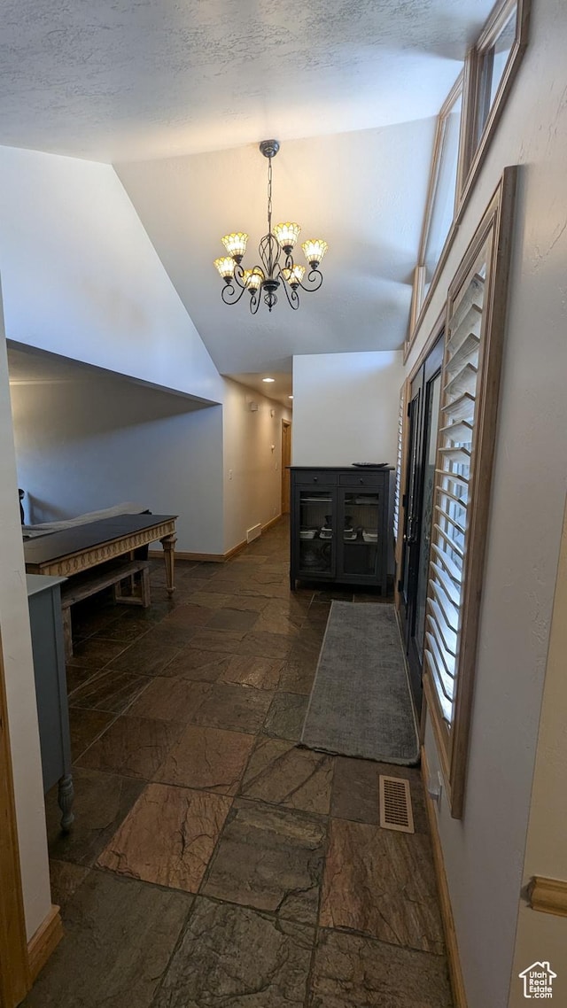 1584 E Petunia Way, Sandy, UT 84092 - corridor featuring stone tile flooring, vaulted ceiling, and a chandelier