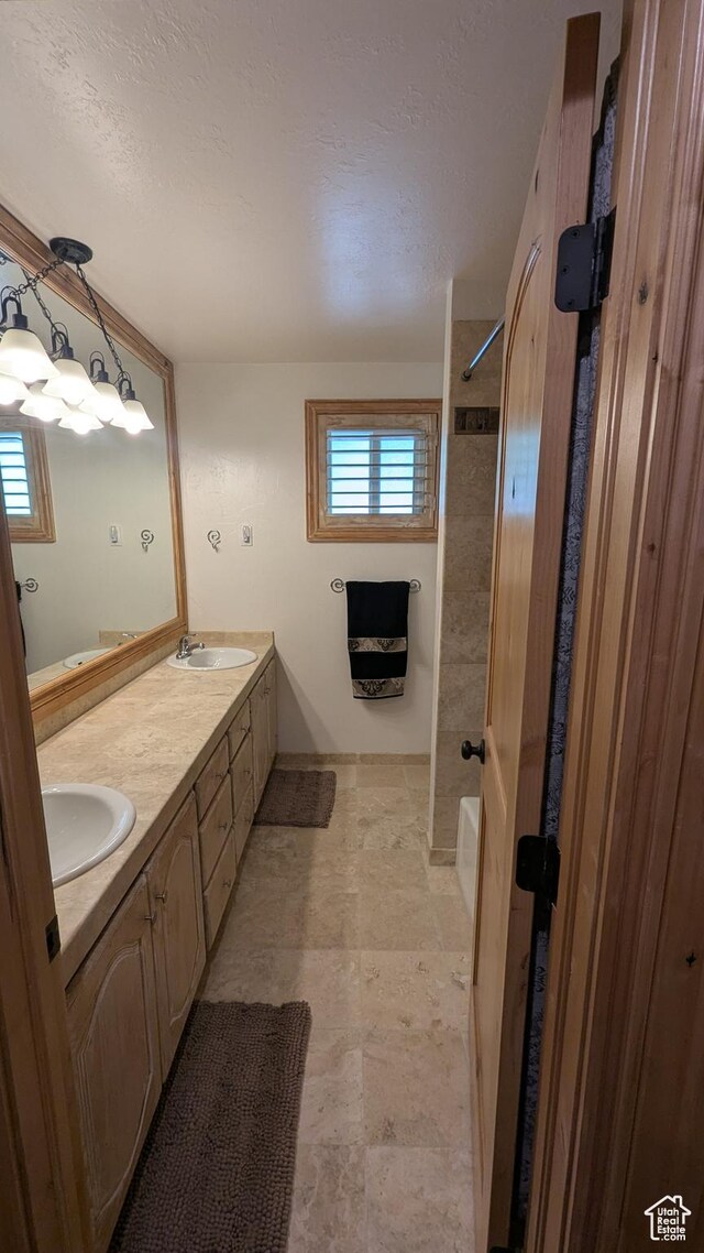 1584 E Petunia Way, Sandy, UT 84092 - full bathroom featuring double vanity, a textured ceiling, and shower / bath combination