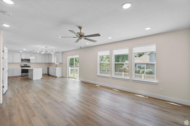 181 W 580 S, Orem, UT 84058 - unfurnished living room featuring a ceiling fan, light wood-type flooring, a textured ceiling, and recessed lighting