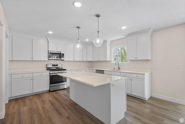 181 W 580 S, Orem, UT 84058 - kitchen featuring appliances with stainless steel finishes, white cabinetry, light countertops, wood finished floors, and a center island