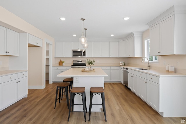 181 W 580 S, Orem, UT 84058 - kitchen with stainless steel appliances, a kitchen breakfast bar, white cabinetry, a kitchen island, and recessed lighting