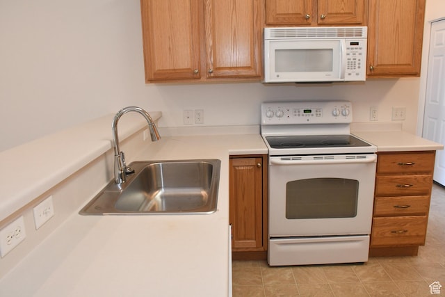 3072 W Leisure Villas Ct, West Jordan, UT 84084 - kitchen with white appliances, light countertops, light tile patterned floors, and brown cabinetry