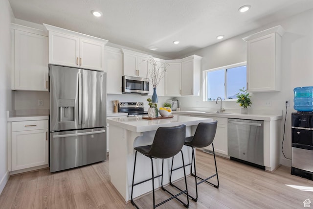 7494 N Silver Ridge Rd Unit 3466, Eagle Mountain, UT 84005 - kitchen featuring stainless steel appliances, white cabinetry, a kitchen bar, light countertops, and recessed lighting