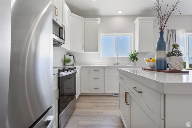 7494 N Silver Ridge Rd Unit 3466, Eagle Mountain, UT 84005 - kitchen with stainless steel appliances, white cabinetry, light countertops, recessed lighting, and light wood-type flooring