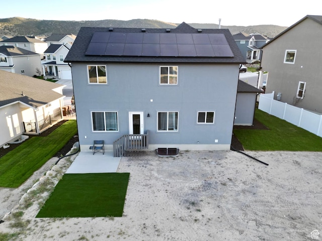 7494 N Silver Ridge Rd Unit 3466, Eagle Mountain, UT 84005 - back of house with roof mounted solar panels, a fenced backyard, a residential view, a patio area, and a mountain view