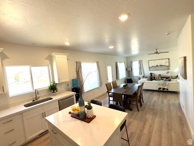 7494 N Silver Ridge Rd Unit 3466, Eagle Mountain, UT 84005 - kitchen featuring white cabinetry, light countertops, open floor plan, light wood finished floors, and recessed lighting