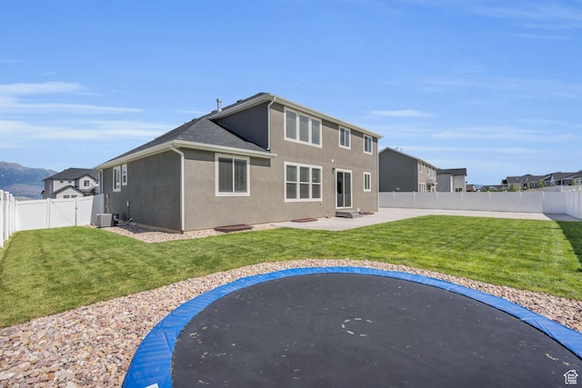 2873 S Puddle Ln, Saratoga Springs, UT 84045 - rear view of property featuring a trampoline, a fenced backyard, and stucco siding