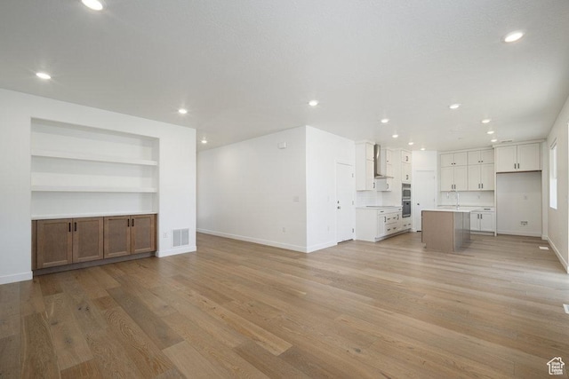 6556 S Jefferson St Unit 15, Murray, UT 84107 - unfurnished living room featuring recessed lighting, light wood-style floors, and built in shelves