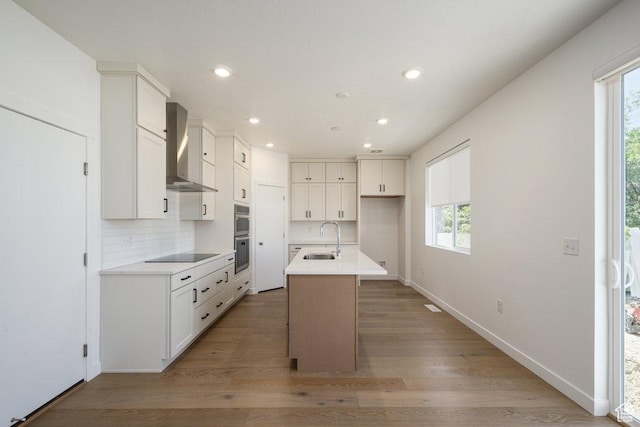 6556 S Jefferson St Unit 15, Murray, UT 84107 - kitchen featuring wall chimney exhaust hood, recessed lighting, black electric stovetop, plenty of natural light, and a center island with sink