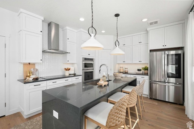 6556 S Jefferson St Unit 15, Murray, UT 84107 - kitchen with stainless steel appliances, wall chimney exhaust hood, dark countertops, white cabinets, and wood finished floors