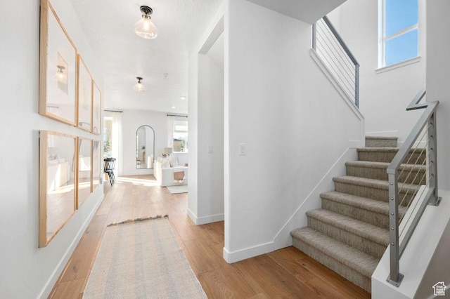 6556 S Jefferson St Unit 15, Murray, UT 84107 - foyer entrance with light wood-type flooring, stairway, and arched walkways