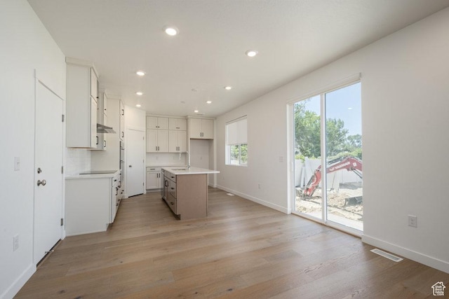 6556 S Jefferson St Unit 15, Murray, UT 84107 - kitchen featuring light wood-style flooring, recessed lighting, white cabinets, light countertops, and a kitchen island with sink