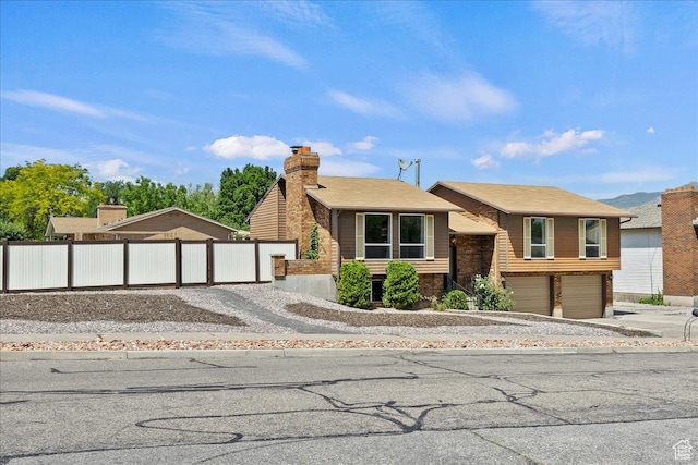 1128 W 4650 S, Riverdale, UT 84405 - view of front of house featuring driveway, a garage, and a chimney