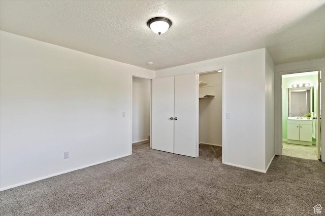 1128 W 4650 S, Riverdale, UT 84405 - unfurnished bedroom with carpet floors, a textured ceiling, a walk in closet, a closet, and ensuite bath