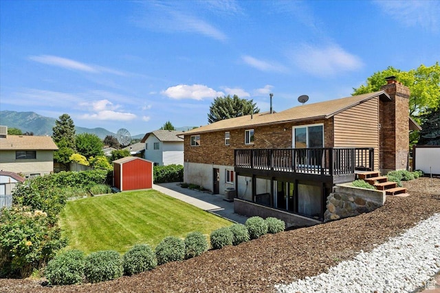 1128 W 4650 S, Riverdale, UT 84405 - rear view of property with a shed, a deck with mountain view, a lawn, a chimney, and a patio area