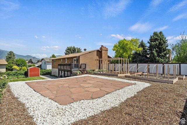 1128 W 4650 S, Riverdale, UT 84405 - view of yard featuring a storage shed, a deck with mountain view, and a patio
