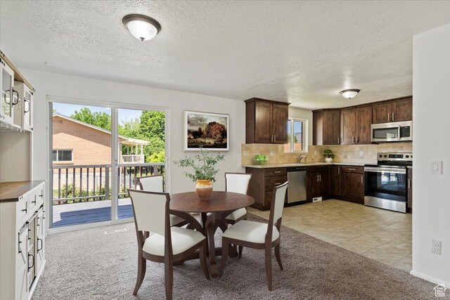1128 W 4650 S, Riverdale, UT 84405 - dining space featuring light colored carpet, plenty of natural light, a textured ceiling, and light tile patterned floors