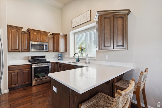 163 Cold Creek Way, Layton, UT 84041 - kitchen with stainless steel appliances, a peninsula, a breakfast bar area, a towering ceiling, and light countertops