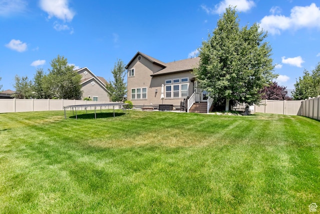 163 Cold Creek Way, Layton, UT 84041 - rear view of house with a trampoline, stucco siding, and a fenced backyard