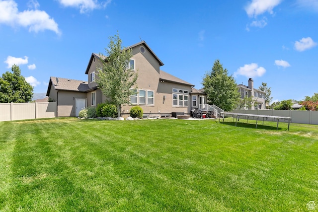 163 Cold Creek Way, Layton, UT 84041 - rear view of property featuring a trampoline, stucco siding, and a fenced backyard