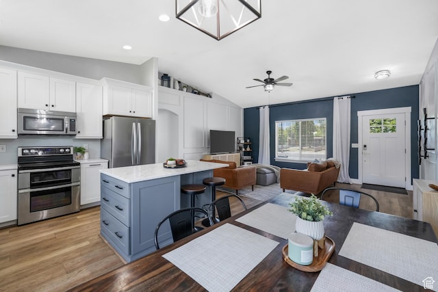 450 N 200 E, Lehi, UT 84043 - kitchen featuring appliances with stainless steel finishes, vaulted ceiling, open floor plan, a center island, and white cabinets