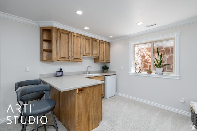 841 E 5875 S, South Ogden, UT 84405 - kitchen featuring a breakfast bar, brown cabinets, dishwashing machine, light countertops, and crown molding