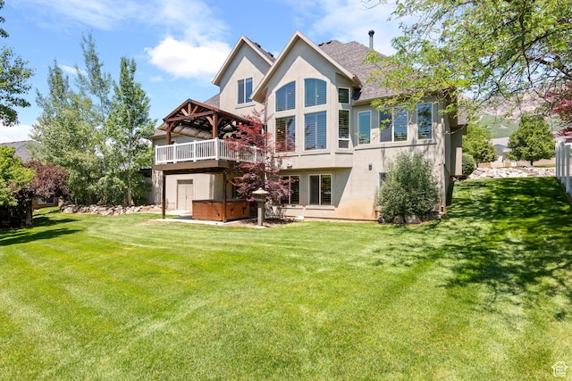 665 E 3550 N, North Ogden, UT 84414 - back of property with a hot tub, stucco siding, a lawn, and a wooden deck
