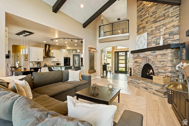 665 E 3550 N, North Ogden, UT 84414 - living area featuring light wood-type flooring, beamed ceiling, arched walkways, a stone fireplace, and high vaulted ceiling