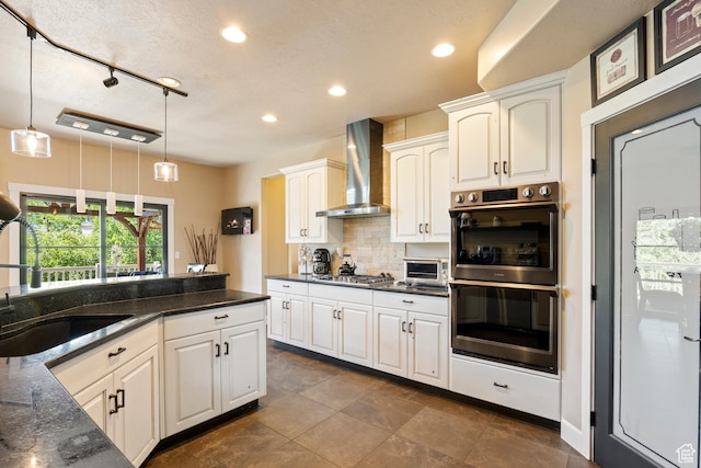 665 E 3550 N, North Ogden, UT 84414 - kitchen featuring wall chimney range hood, stainless steel appliances, hanging light fixtures, recessed lighting, and decorative backsplash