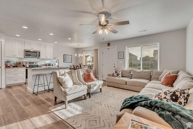940 N Center St, Santaquin, UT 84655 - living room featuring plenty of natural light, a ceiling fan, light wood-type flooring, recessed lighting, and a chandelier