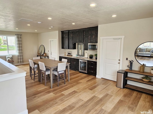 940 N Center St, Santaquin, UT 84655 - kitchen featuring dark cabinets, wine cooler, a textured ceiling, stainless steel microwave, and recessed lighting