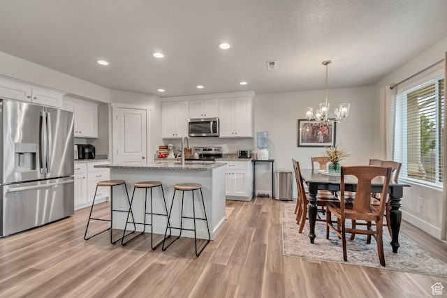 940 N Center St, Santaquin, UT 84655 - kitchen with stainless steel appliances, light wood-style floors, a chandelier, white cabinetry, and recessed lighting