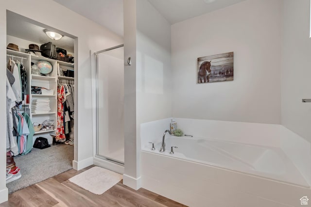 940 N Center St, Santaquin, UT 84655 - bathroom with a walk in closet, a garden tub, a shower stall, and wood finished floors