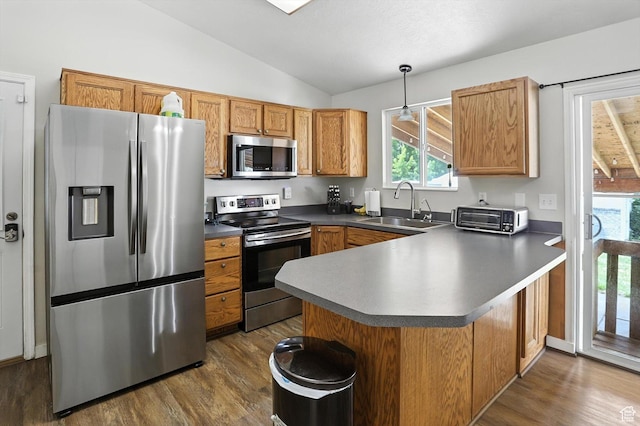 416 N 450 W, Clearfield, UT 84015 - kitchen featuring stainless steel appliances, vaulted ceiling, dark wood-style floors, a peninsula, and healthy amount of natural light