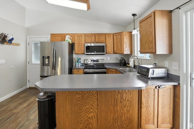 416 N 450 W, Clearfield, UT 84015 - kitchen featuring stainless steel appliances, lofted ceiling, wood finished floors, a peninsula, and brown cabinetry