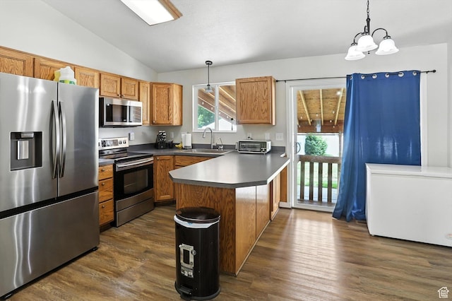 416 N 450 W, Clearfield, UT 84015 - kitchen featuring appliances with stainless steel finishes, lofted ceiling, a peninsula, dark wood-style floors, and pendant lighting