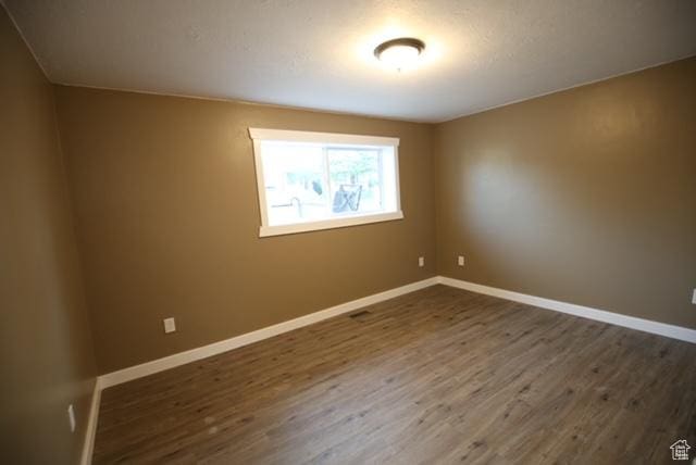 591 E Acoma Rd A-B, Unit A-B Midvale, UT 84047 - spare room featuring dark wood-style flooring and baseboards