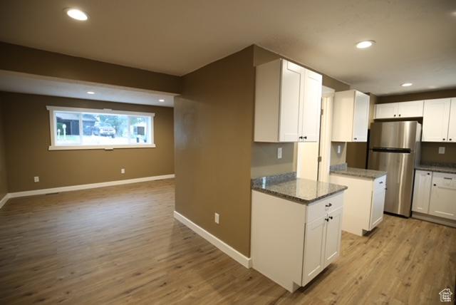 591 E Acoma Rd A-B, Unit A-B Midvale, UT 84047 - kitchen featuring freestanding refrigerator, white cabinetry, wood finished floors, recessed lighting, and open floor plan