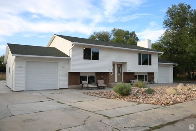 591 E Acoma Rd A-B, Unit A-B Midvale, UT 84047 - split foyer home with an attached garage, driveway, and a chimney