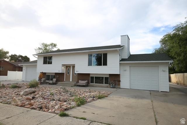 591 E Acoma Rd A-B, Unit A-B Midvale, UT 84047 - bi-level home with a garage, driveway, and a chimney