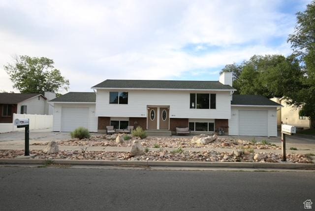 591 E Acoma Rd A-B, Unit A-B Midvale, UT 84047 - split foyer home with a garage, driveway, and a chimney