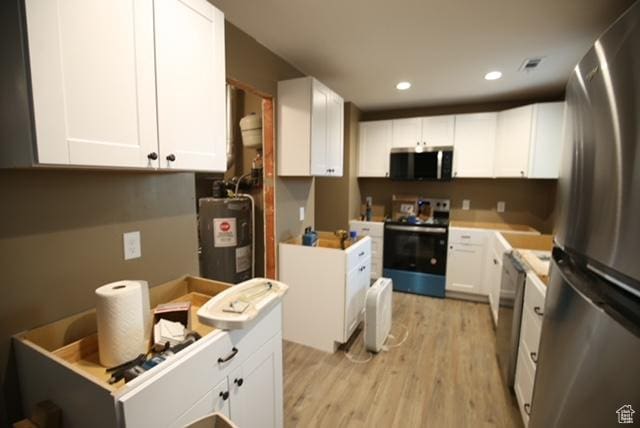 591 E Acoma Rd A-B, Unit A-B Midvale, UT 84047 - kitchen with appliances with stainless steel finishes, electric water heater, light wood-style flooring, white cabinets, and recessed lighting