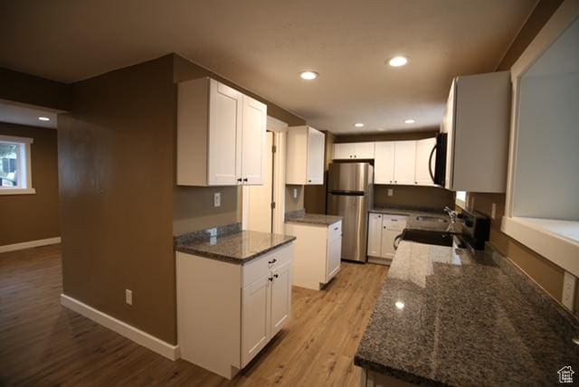 591 E Acoma Rd A-B, Unit A-B Midvale, UT 84047 - kitchen with freestanding refrigerator, black microwave, stove, light wood-style floors, and dark stone counters