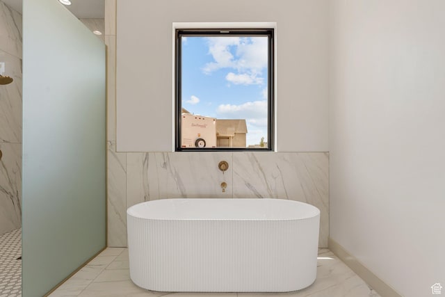 1762 S 920 W, Hurricane, UT 84737 - bathroom featuring marble look tiles, tile walls, a freestanding bath, and a wainscoted wall