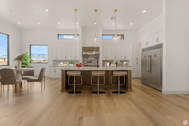 1762 S 920 W, Hurricane, UT 84737 - kitchen featuring built in refrigerator, white cabinets, light wood-style flooring, light countertops, and under cabinet range hood