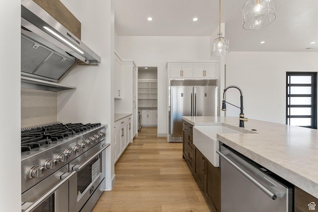 1762 S 920 W, Hurricane, UT 84737 - kitchen featuring high quality appliances, ventilation hood, white cabinetry, light wood-style flooring, and light countertops