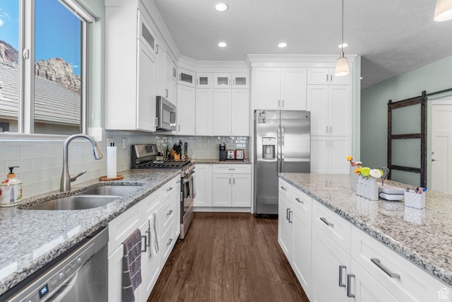 130 Matilda Ln, Springdale, UT 84767 - kitchen with stainless steel appliances, a barn door, tasteful backsplash, white cabinetry, and recessed lighting